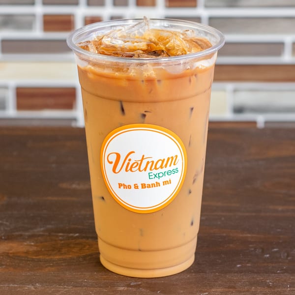Iced Vietnamese coffee in a clear plastic cup with a "Vietnam Express" logo.